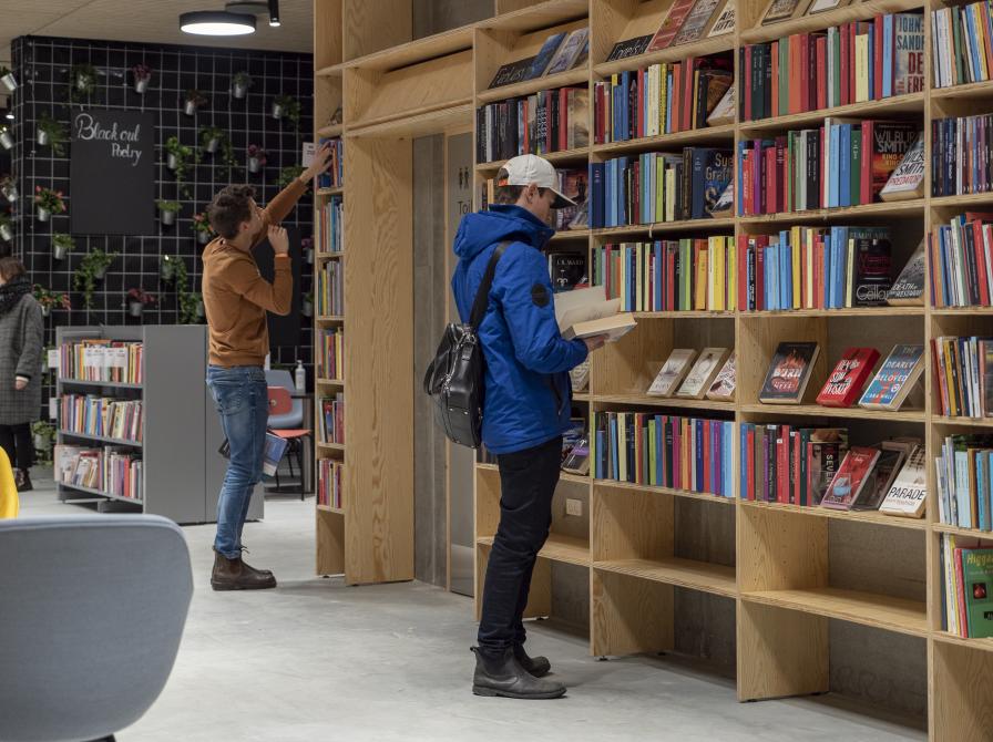 Biblioteksbøger og folk der læser bøger.